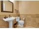 Charming powder room with pedestal sink and decorative tile accents at 1708 W Gambit Trl, Phoenix, AZ 85085