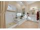 Bright bathroom featuring a soaking tub with tile surround and a glass enclosed shower at 1708 W Gambit Trl, Phoenix, AZ 85085