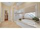 Bright bathroom featuring a soaking tub with tile surround and a glass enclosed shower at 1708 W Gambit Trl, Phoenix, AZ 85085