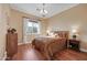 Cozy bedroom with hardwood floors, a chandelier, and natural light at 1708 W Gambit Trl, Phoenix, AZ 85085