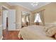 Bedroom with wood floors, natural light, full-length mirror, neutral colored walls and window coverings at 1708 W Gambit Trl, Phoenix, AZ 85085