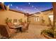 Inviting outdoor courtyard with comfortable seating, a cozy fire pit, and ambient string lights at 1708 W Gambit Trl, Phoenix, AZ 85085