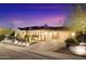 Twilight view of the home featuring stone accents, a three-car garage, and desert landscaping at 1708 W Gambit Trl, Phoenix, AZ 85085