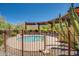 A cozy hot tub sits in a secluded setting, surrounded by desert flora and a metal fence at 1708 W Gambit Trl, Phoenix, AZ 85085