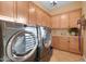 The laundry room features neutral cabinets and modern appliances at 1708 W Gambit Trl, Phoenix, AZ 85085