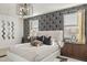 Serene bedroom featuring modern lighting fixture, accent wall, and bedside tables at 17725 W Onyx Ave, Waddell, AZ 85355