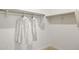 Bright walk-in closet with white shirts hanging on the rack at 17725 W Onyx Ave, Waddell, AZ 85355