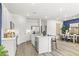 Open-concept kitchen featuring stainless steel appliances, a center island with barstool seating, and wood-look flooring at 17801 W Mission Ln, Waddell, AZ 85355