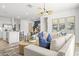 Open-concept living room with a view of the kitchen, dining area, comfortable seating, and contemporary decor at 17801 W Mission Ln, Waddell, AZ 85355