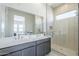 Modern bathroom featuring double vanity, glass-enclosed shower, and subway tile at 17966 W Long Lake Rd, Goodyear, AZ 85338