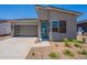 Attractive single Gathering home showcasing desert landscaping, a gray garage door, and a bright blue front door at 17966 W Long Lake Rd, Goodyear, AZ 85338