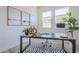 Bright home office featuring a modern desk, stylish decor, and ample natural light from multiple windows at 17966 W Long Lake Rd, Goodyear, AZ 85338