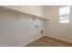 Bright laundry room with built-in shelving and utility connections, offering convenience at 17966 W Long Lake Rd, Goodyear, AZ 85338