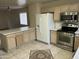 Traditional kitchen featuring stainless steel appliances, light wood cabinets, and tile flooring with mosaic accents at 18239 N 40Th St # 115, Phoenix, AZ 85032