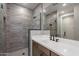 Modern bathroom features a double sink vanity and a stone-look tile shower with a glass partition at 2121 W Sonoran Desert Dr # 95, Phoenix, AZ 85085