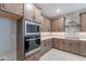 This kitchen features built-in stainless appliances, neutral backsplash tile, and stained cabinets at 2121 W Sonoran Desert Dr # 95, Phoenix, AZ 85085