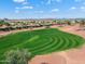 Scenic aerial view of lush golf course with well-manicured greens and surrounding homes under a bright, sunny sky at 23024 N De La Guerra Ct, Sun City West, AZ 85375