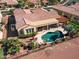 Stunning aerial view of a backyard oasis featuring a private pool, covered patio, and mature landscaping at 23024 N De La Guerra Ct, Sun City West, AZ 85375