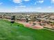 Beautiful aerial shot of the community and golf course with golf carts on the green and mountain views in the background at 23024 N De La Guerra Ct, Sun City West, AZ 85375