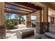 Covered back porch featuring stone columns, lounge furniture, and view of golf course at 23024 N De La Guerra Ct, Sun City West, AZ 85375