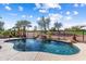 Sparkling pool with rock waterfall feature, surrounded by lush greenery and a golf course view at 23024 N De La Guerra Ct, Sun City West, AZ 85375