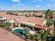 Aerial view of a backyard oasis with a sparkling pool, shaded patio, and beautifully landscaped surroundings at 23024 N De La Guerra Ct, Sun City West, AZ 85375