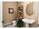 Half bathroom with modern fixtures, a pedestal sink, and tiled flooring at 23024 N De La Guerra Ct, Sun City West, AZ 85375