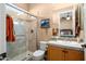 Tiled bathroom featuring walk-in shower, marble floors, and wood vanity at 23024 N De La Guerra Ct, Sun City West, AZ 85375