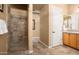 Tiled bathroom featuring step-in shower, marble floors, and wood vanity at 23024 N De La Guerra Ct, Sun City West, AZ 85375