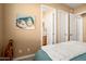 Bedroom featuring wall art, view of bathroom, and closet space at 23024 N De La Guerra Ct, Sun City West, AZ 85375