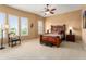 Bedroom featuring a ceiling fan, carpet flooring, and decorative windows at 23024 N De La Guerra Ct, Sun City West, AZ 85375