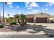 Beautiful single-story home showcasing desert landscaping, a three-car garage, and a charming stone exterior at 23024 N De La Guerra Ct, Sun City West, AZ 85375