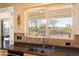 Kitchen sink with granite countertops, tiled backsplash, and a window view of the backyard at 23024 N De La Guerra Ct, Sun City West, AZ 85375