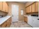 Spacious laundry room featuring ample cabinets, counter space, and washer and dryer at 23024 N De La Guerra Ct, Sun City West, AZ 85375