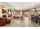 Spacious living room featuring an entertainment center, fireplace, tiled floors, and access to the patio at 23024 N De La Guerra Ct, Sun City West, AZ 85375