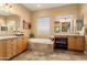 Spacious bathroom with dual vanities, soaking tub, and tiled flooring at 23024 N De La Guerra Ct, Sun City West, AZ 85375