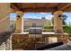 Inviting outdoor kitchen with stainless steel grill and stone accents, perfect for entertaining at 23024 N De La Guerra Ct, Sun City West, AZ 85375