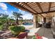 Relaxing outdoor patio with a pool, water feature, and lush landscaping at 23024 N De La Guerra Ct, Sun City West, AZ 85375