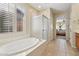 Bright bathroom featuring soaking tub, glass shower, and natural light at 2534 W Muirfield Dr, Anthem, AZ 85086