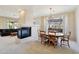 Cozy dining room featuring a fireplace, chandelier, and large windows with natural light at 2534 W Muirfield Dr, Anthem, AZ 85086