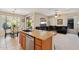 Open-concept kitchen area with granite countertop island, wood cabinets and adjacent living room at 2534 W Muirfield Dr, Anthem, AZ 85086