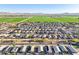 Breathtaking aerial shot capturing the neighborhood, green fields, and mountains against a clear blue sky at 25634 W Samantha Way, Buckeye, AZ 85326