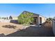 View of backyard showcasing compact patio area and young shade tree in rock landscaping at 25634 W Samantha Way, Buckeye, AZ 85326