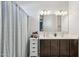 Bathroom featuring double sinks, cabinet, and shower with curtain at 25634 W Samantha Way, Buckeye, AZ 85326