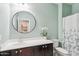 Bright bathroom with modern fixtures, white vanity, and a round mirror, next to a toilet and shower at 25634 W Samantha Way, Buckeye, AZ 85326