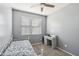 Bright bedroom with neutral carpet, ceiling fan, and natural light, featuring a functional desk area at 25634 W Samantha Way, Buckeye, AZ 85326