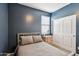 Calming bedroom with navy blue walls, a wood frame bed, and storage, with a view of closet at 25634 W Samantha Way, Buckeye, AZ 85326