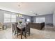 Open-concept living and dining area with neutral paint, tile flooring, and sliding door to patio at 25634 W Samantha Way, Buckeye, AZ 85326