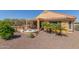 Landscaped backyard with fire pit, covered patio and desert plants at 26237 W Vista North Dr, Buckeye, AZ 85396