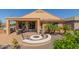 Private backyard with a covered patio, fire pit, and low-maintenance desert landscaping at 26237 W Vista North Dr, Buckeye, AZ 85396